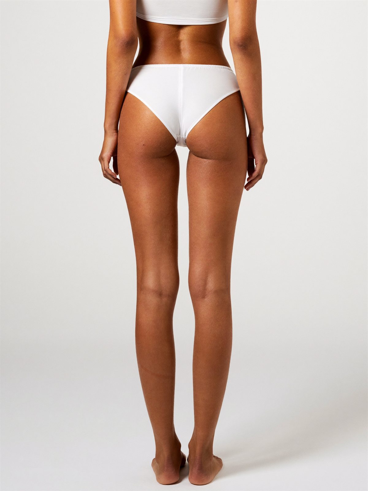 Vista posterior de figura femenina en ropa interior blanca